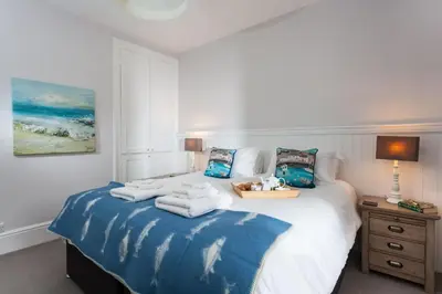 a bedroom with a bed with towels on it at Verity Cottage in St Merryn