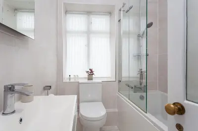 a bathroom with a toilet and a sink and a shower at Verity Cottage in St Merryn