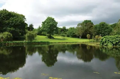 a body of water with trees in the background at Mews Cottage in Helston