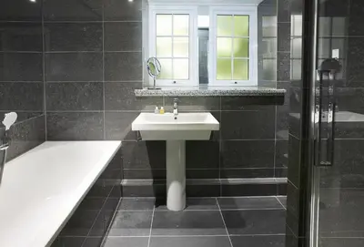 a bathroom with a sink and a bath tub and a window at St Corantyn Cottage in Helston