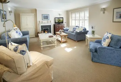 a living room with blue furniture and a fireplace at St Corantyn Cottage in Helston