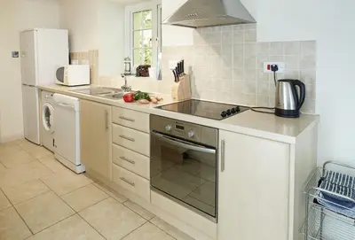 a kitchen with a sink and a stove top oven at St Corantyn Cottage in Helston