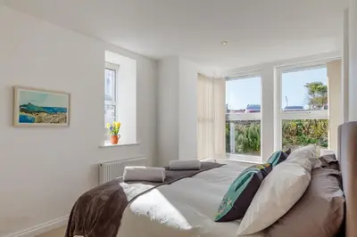 a bedroom with a large bed in front of two windows at 2 Bed in St. Ives oc-1seab in St Ives