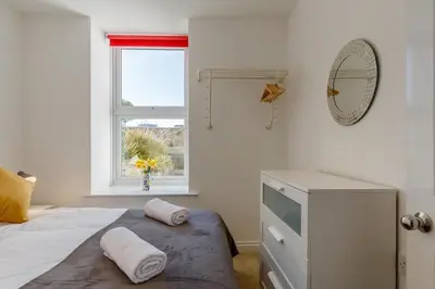 a bedroom with a bed and a dresser and a window at 2 Bed in St. Ives oc-1seab in St Ives