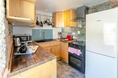 a kitchen with wooden cabinets and a white refrigerator at 2 Bed in St. Ives oc-6acarr in St Ives