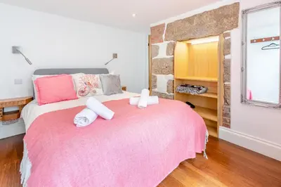 a bedroom with a pink bed with two towels on it at 2 Bed in St. Ives oc-6carr in St Ives