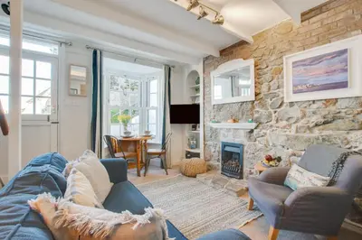 a living room with a blue couch and a stone wall at 2 Bed in St Ives oc-albt02 in St Ives