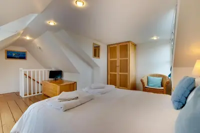 a bedroom with a large white bed and a desk at 3 Bed in St Ives oc-bail05 in St Ives