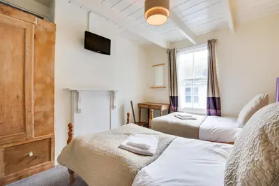 a bedroom with two beds and a tv on the wall at 3 Bed in St Ives oc-bail06 in St Ives