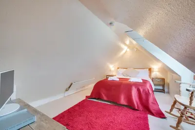 a attic bedroom with a red bed and a red rug at 3 Bed in St Ives oc-bail06 in St Ives