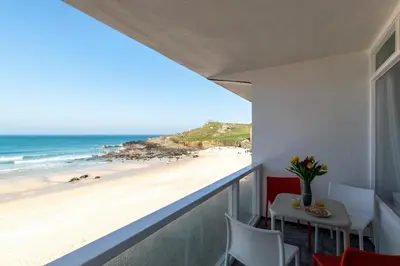 a balcony with a table and a view of the beach at 2 Bed in St Ives oc-bpp15 in St Ives