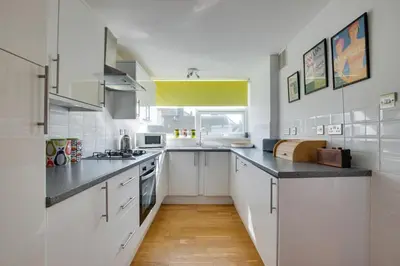 a kitchen with white cabinets and black counter tops at 2 Bed in St Ives oc-bpp15 in St Ives