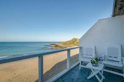 a balcony with two chairs and the beach at 1 Bed in St Ives oc-bpp21 in St Ives
