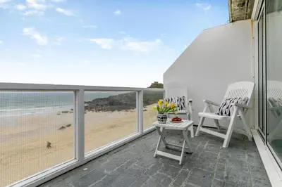 a balcony with chairs and a view of the beach at 1 Bed in St Ives oc-bpp21 in St Ives