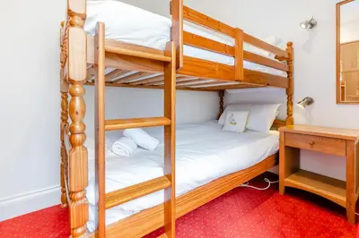 a bunk bed room with two bunk beds and a desk at 4 Bed in St. Ives oc-brhous in St Ives