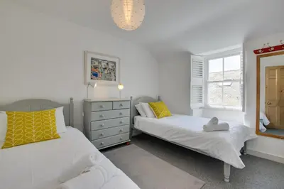 a bedroom with two beds and a dresser and a mirror at 3 Bed in St Ives oc-car17 in St Ives
