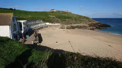 a view of a beach with a house and the ocean at 3 Bed in St Ives oc-car17 in St Ives