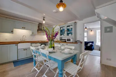 a kitchen and dining room with a blue table and chairs at 3 Bed in St Ives oc-car17 in St Ives