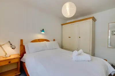 a bedroom with a large white bed and a lamp at 3 Bed in St Ives oc-car17 in St Ives
