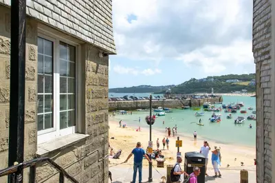 a group of people on a beach next to a building at 1 Bed in St Ives oc-chyr2 in St Ives