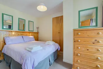 a bedroom with a bed and a dresser with towels on it at 1 Bed in St Ives oc-chyr2 in St Ives