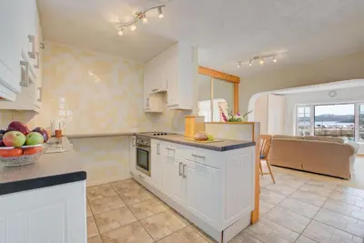 a kitchen with white cabinets and a couch in the background at 1 Bed in St Ives oc-chyr2 in St Ives