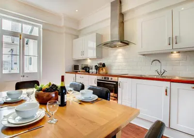 a kitchen with a wooden table with a bottle of wine at 2 Bed in St Ives oc-clv2a in St Ives