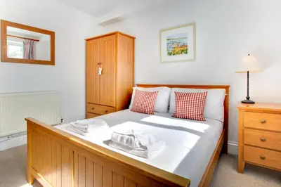 a bedroom with a large bed and a wooden cabinet at 2 Bed in St Ives oc-clv2a in St Ives