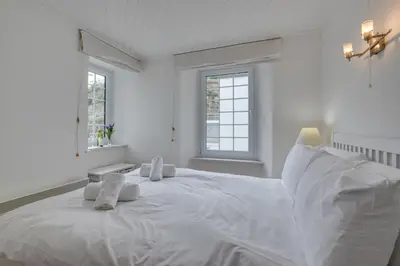 a white bedroom with a large white bed with towels on it at 1 Bed in St Ives oc-crab02 in St Ives