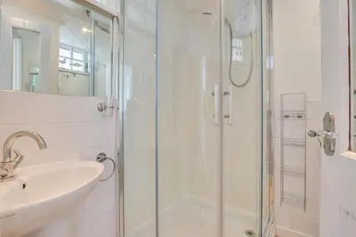 a white bathroom with a shower and a sink at 1 Bed in St Ives oc-crab02 in St Ives