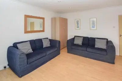 a living room with two blue couches and a mirror at 1 Bed in St Ives oc-clear2 in St Ives