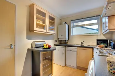 a kitchen with white cabinets and a counter with fruit on it at 1 Bed in St Ives oc-clear2 in St Ives