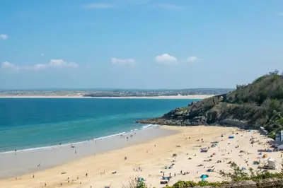 a group of people on a beach near the ocean at 1 Bed in St Ives oc-cwn014 in St Ives