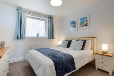 a bedroom with a large bed and two windows at 1 Bed in St Ives oc-cwn014 in St Ives