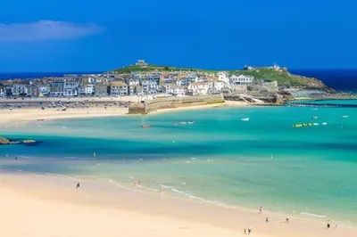 a group of people on a beach near the water at 1 Bed in St Ives oc-cwn054 in St Ives