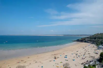 a group of people on a beach with the ocean at 1 Bed in St Ives oc-cwn054 in St Ives