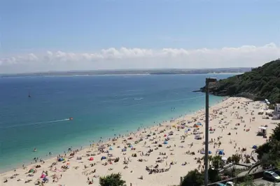 a group of people on a beach with the ocean at 1 Bed in St Ives oc-cwn31 in St Ives