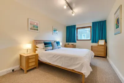 a bedroom with a large bed with blue curtains at 1 Bed in St Ives oc-cwn31 in St Ives
