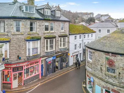 a person walking down a city street with buildings at 1 Bed in St Ives oc-decke in St Ives