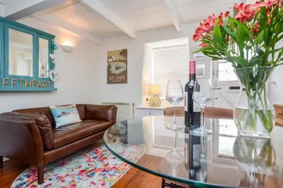 a living room with a glass table with a vase of flowers at 1 Bed in St Ives oc-dgy028 in St Ives