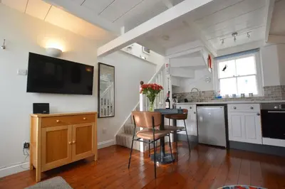 a kitchen with a table and a tv on the wall at 1 Bed in St Ives oc-dgy028 in St Ives