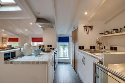 a kitchen with white cabinets and a large counter top at 1 Bed in St. Ives oc-drift4 in St Ives