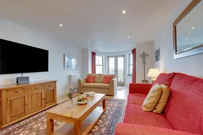 a living room with a red couch and a flat screen tv at 2 Bed in St Ives oc-f1meor in St Ives