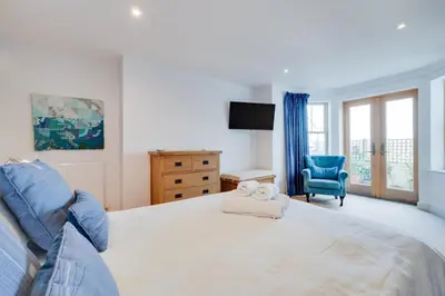 a bedroom with a large bed and a blue chair at 2 Bed in St Ives oc-f1meor in St Ives