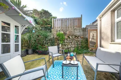 a patio with chairs and a table and a fence at 1 Bed in St. Ives oc-farr in St Ives