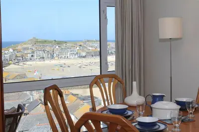 a dining room table with a view of a beach at 2 Bed in St Ives oc-fern41 in St Ives