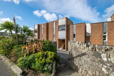 an exterior view of a brick building with a stone wall at 2 Bed in St Ives oc-gmn19 in Carbis Bay