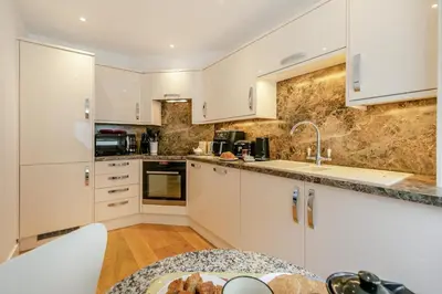 a kitchen with white cabinets and a table in it at 2 Bed in St Ives oc-godct7 in Carbis Bay