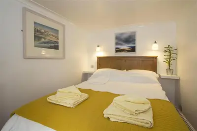 a bedroom with a bed with towels on it at Hideaway Tremayne in St Ives