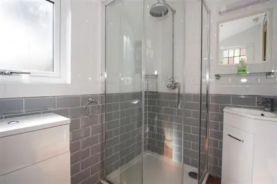a bathroom with a glass shower with a sink at Hideaway Tremayne in St Ives